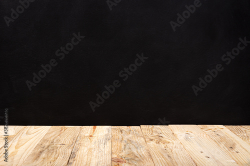 Empty wooden deck table table over black wall background