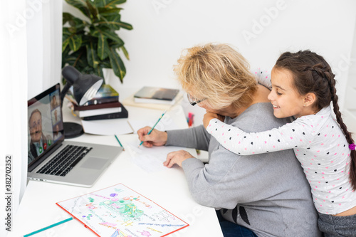 Helpful granny. Helpful loving granny assisting her cute granddaughter making homework