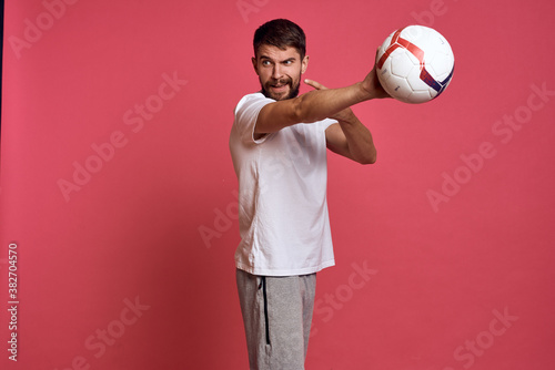 Man with a soccer ball on a pink background energy gesticulate with his hands coach emotions model