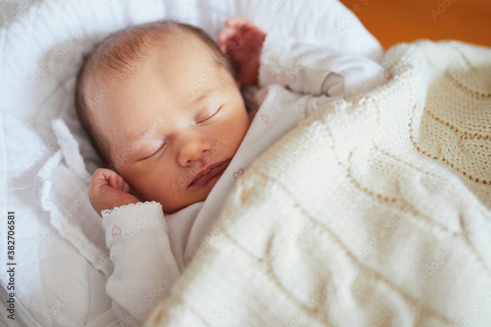 Newborn baby sleeping under knitted blanket Newborn baby sleeping under knitted blanket