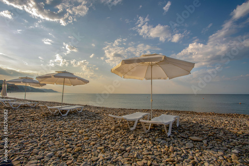 Konstfotografi Idyllic morning on the beach: sun loungers and sun umbrellas - the territory of