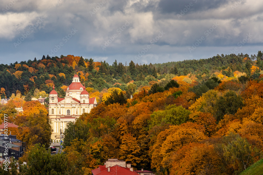 Vilnius city view of a church with colorful trees in autumn.