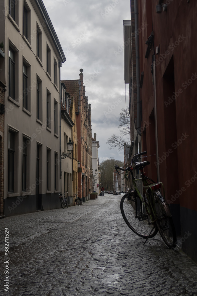 Bike on the streets of Bruges. Bike with buildings and cloudy day. Old bike on the streets