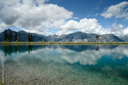 Klares Wasser eines Sees in Krahberg / Österreich mit weiter Gebirgskette im Hintergrund