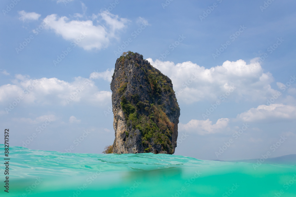 rock in the Andaman Sea against cloudy blue skies, Thailand