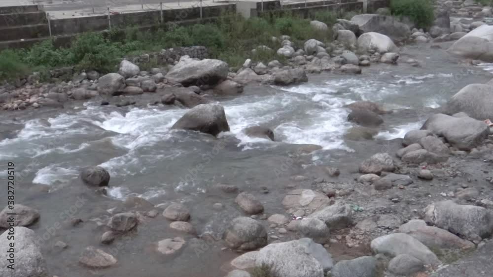 Medium, white water stream flows through a rocky bed, Kangra, India