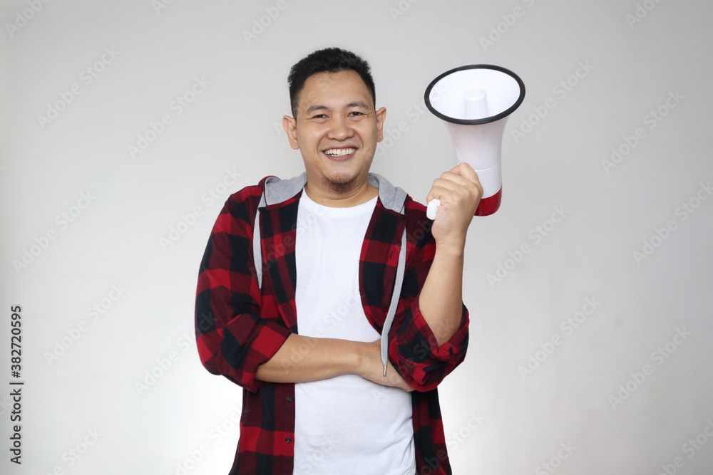 Portrait of proud young confident Asian man holding megaphone, looking at camera and smiling, over white Portrait of proud young confident Asian man holding megaphone, looking at camera and smiling, over white