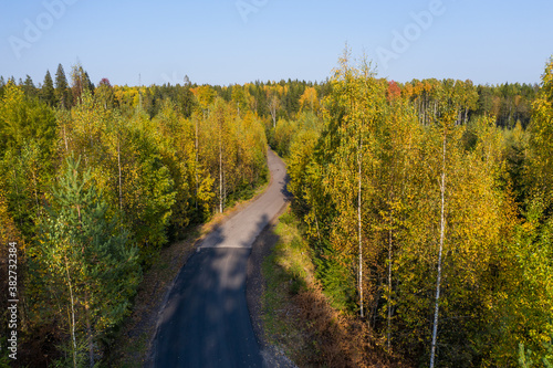 Fototapeta Naklejka Na Ścianę i Meble -  Aerial view of the road in the autumn forest in Karelia