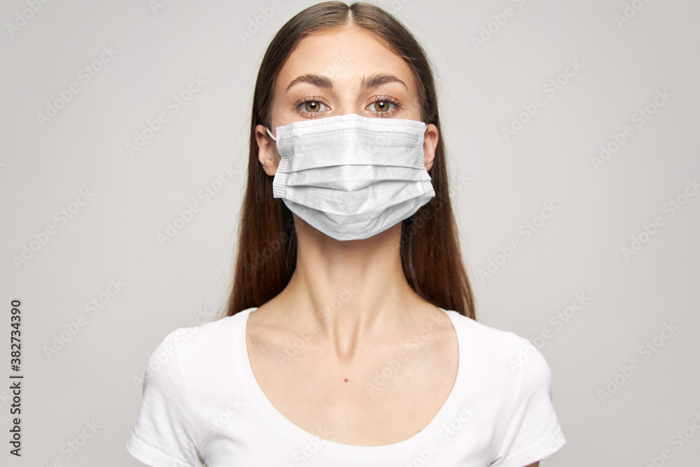 Pretty woman medical face mask look ahead close-up white t-shirt Pretty woman medical face mask look ahead close-up white t-shirt