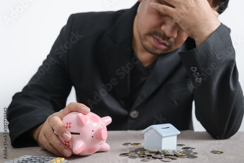 Businessman is stressed out of losing their jobs and insufficient savings to pay for a mortgage. photo