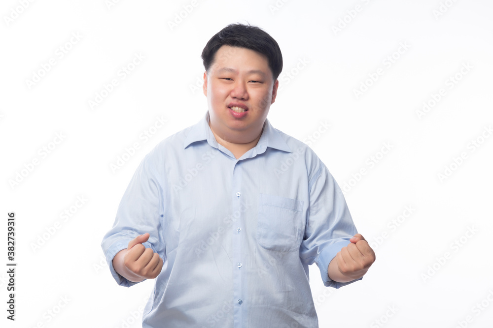 Young Fat Asian business man raising his fists with funny face isolated on white background. Young Fat Asian business man raising his fists with funny face isolated on white background.