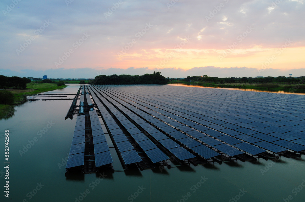 Sunset rays over solar panels on the lake.