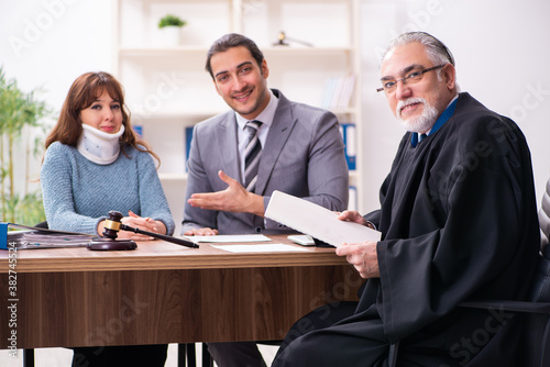 Young woman in courthouse with judge and lawyer photo