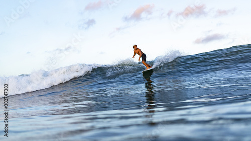 Photography Young male athlete swimming on surfing board on the ocean