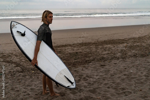 A surfer walking in from the water after a day out on the waves in Bali, Indonesia.Bali, Indonesia