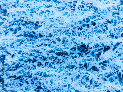 Arial view of splashing oceanic waves with bubbles and foam. Copy space. High quality photo