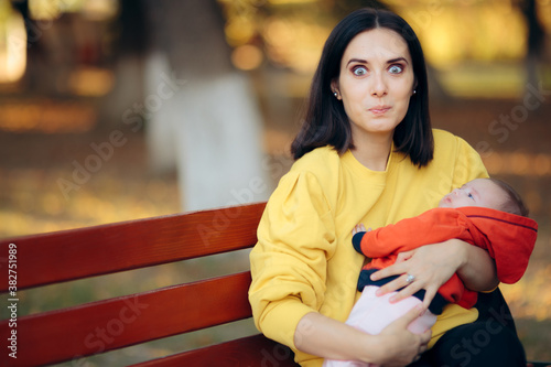 Happy Mother Holding Baby on A Bench in the Park