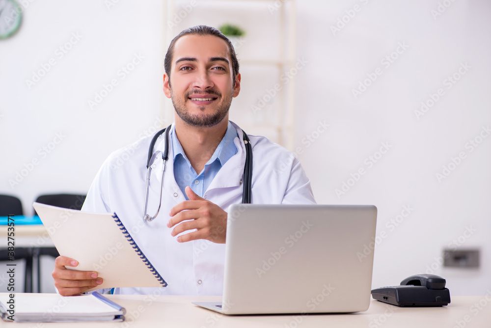 Young handsome male doctor working in the clinic Young handsome male doctor working in the clinic