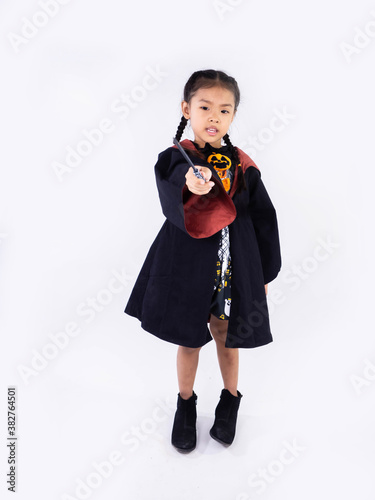 Asian children girl in witch dress costume Casting magic for Halloween decoration in white background
