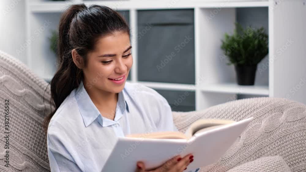 Brazilian woman read interesting book turning paper page. Medium close up shot on 4k RED camera Brazilian woman read interesting book turning paper page. Medium close up shot on 4k RED camera