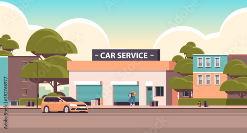 car repair service concept mechanic in uniform repairing tire man working and fixing wheel maintenance station building horizontal vector illustration