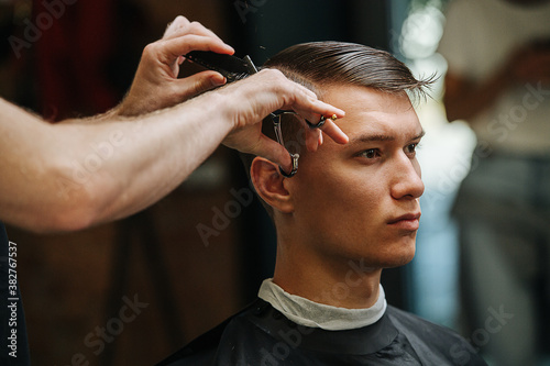 Self-respecting serious young man in a barber shop