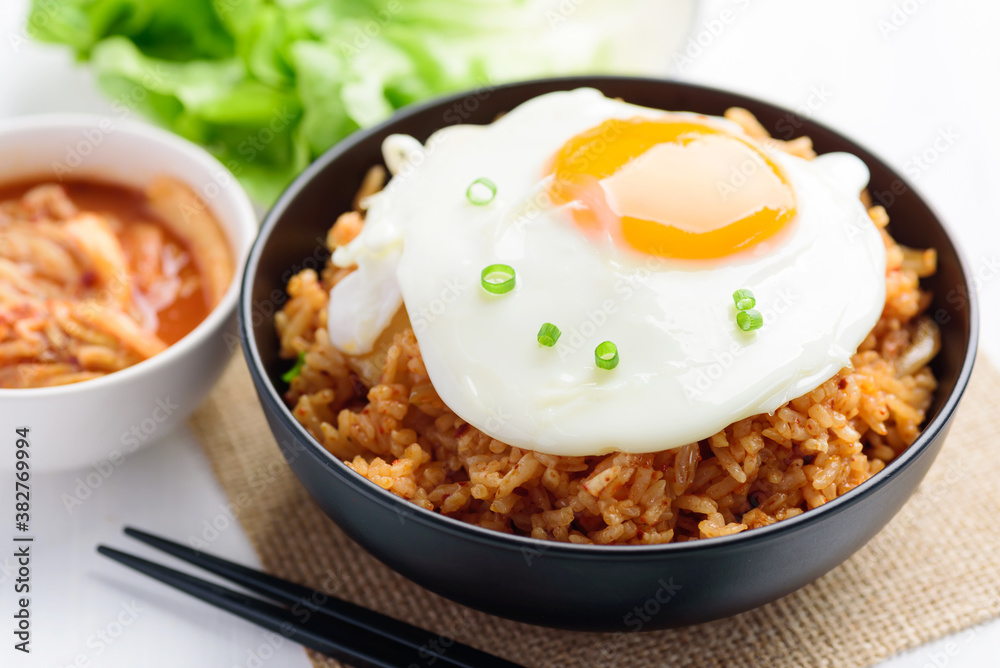 Korean food, Kimchi fried rice with fried egg on top in a bowl Korean food, Kimchi fried rice with fried egg on top in a bowl
