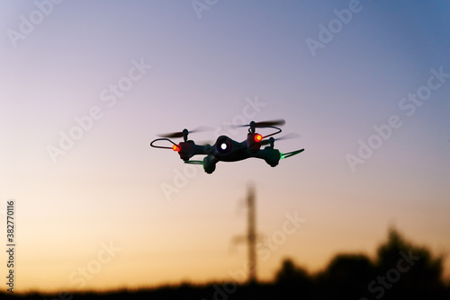 Toy drone quad copter against sunset sky