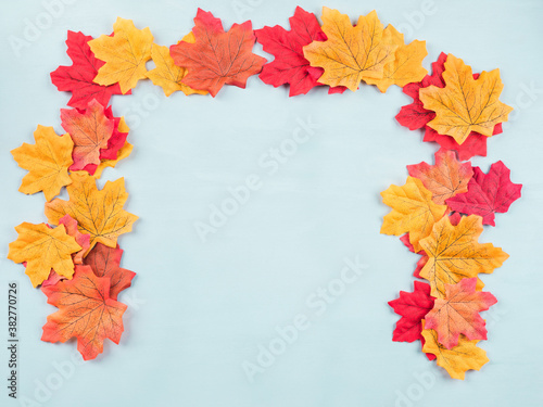 Colorful autumn maple leaves on turquoise background. Flat lay frame