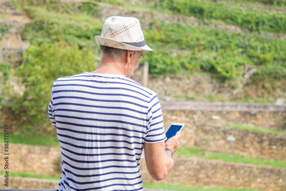 Fototapeta premium tourist with hat and mobile phone in the field
