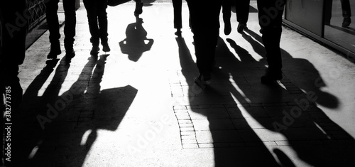 Blurry shadow silhouette of  people walking on pedestrian street in black and white