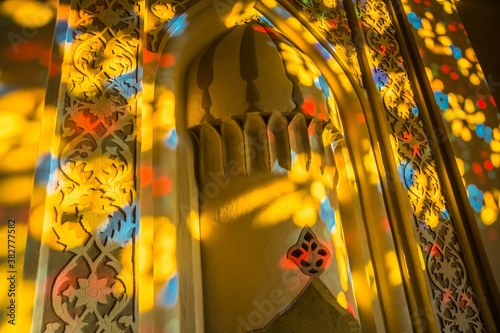 Sunlight through the stained glass window in the Palace of Shaki Khans, Azerbaijan. Vibrant spots on the wall with patterns.