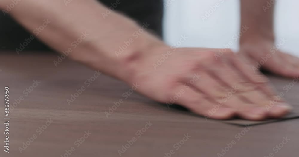 Slow motion of man hand sanding toned walnut table surface before applying finish Slow motion of man hand sanding toned walnut table surface before applying finish