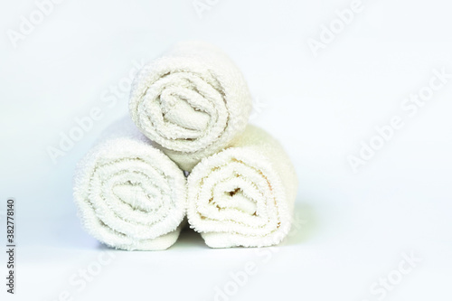Stack of bath white rolled towels on light background