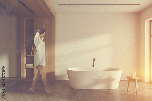 Woman walking in white and wooden bathroom