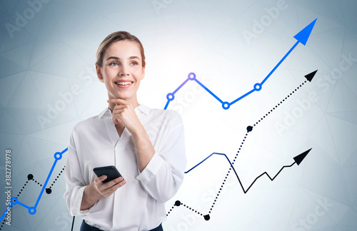 Smiling woman with phone, growing graphs