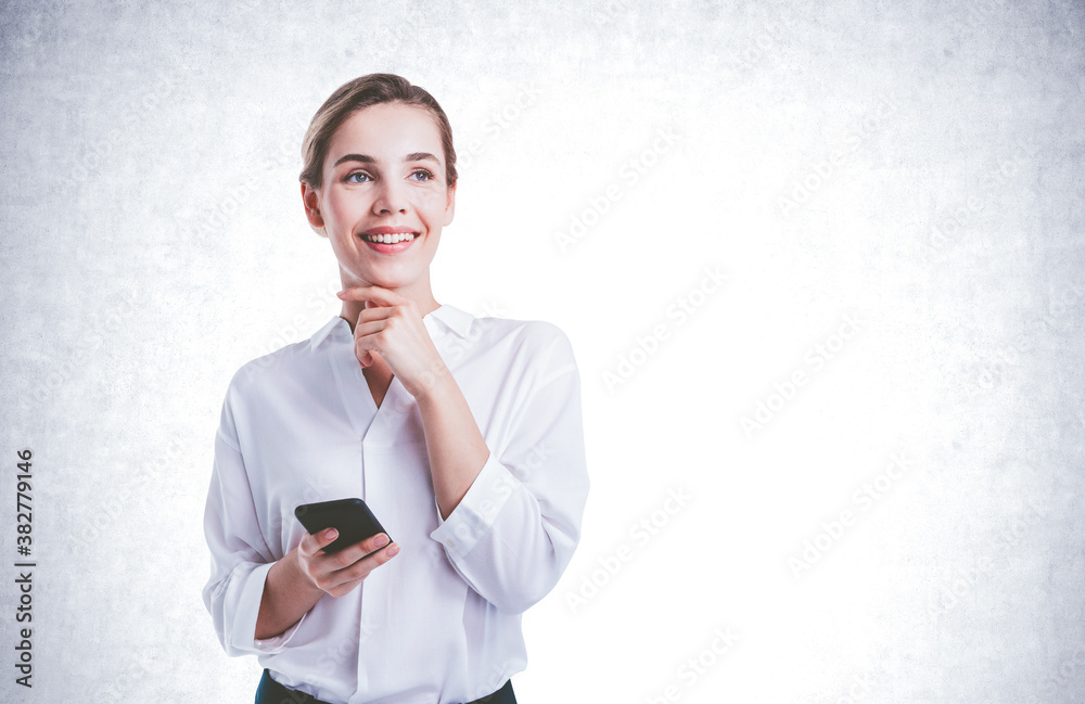 Smiling young businesswoman with smartphone