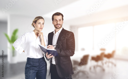 Thinking businessman and businesswoman in office