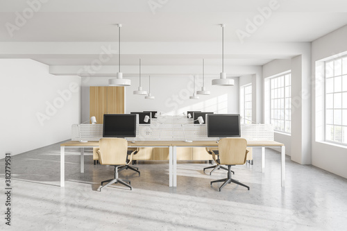 Modern white open space office with wooden tables