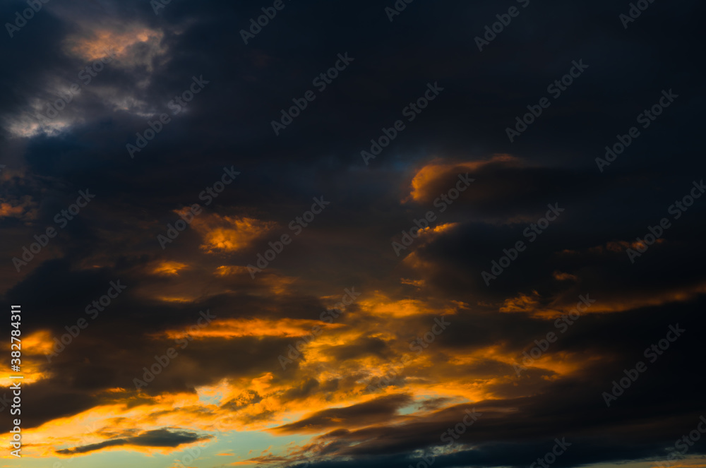 Beautiful sunset. Black and yellow clouds in the sky