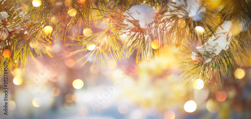 Happy New Year and Merry Christmas Background with Snow Pine Branches. Winter Natural Holiday Landscape with trees and golden bokeh lights. Banner with Copy Space © 5ph