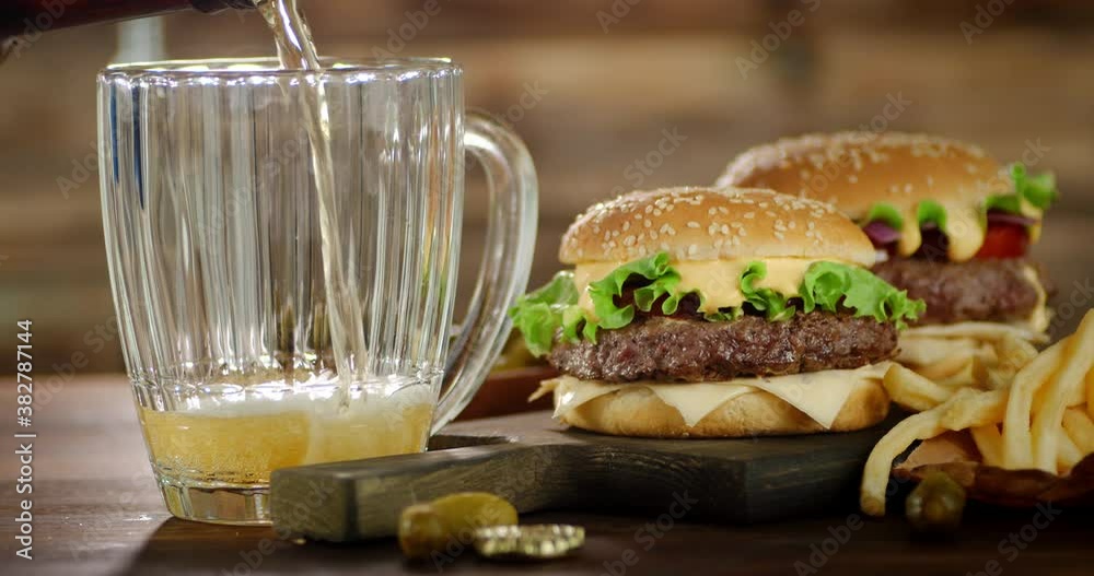 On the table are delicious burgers and a glass of beer. On the table are delicious burgers and a glass of beer.