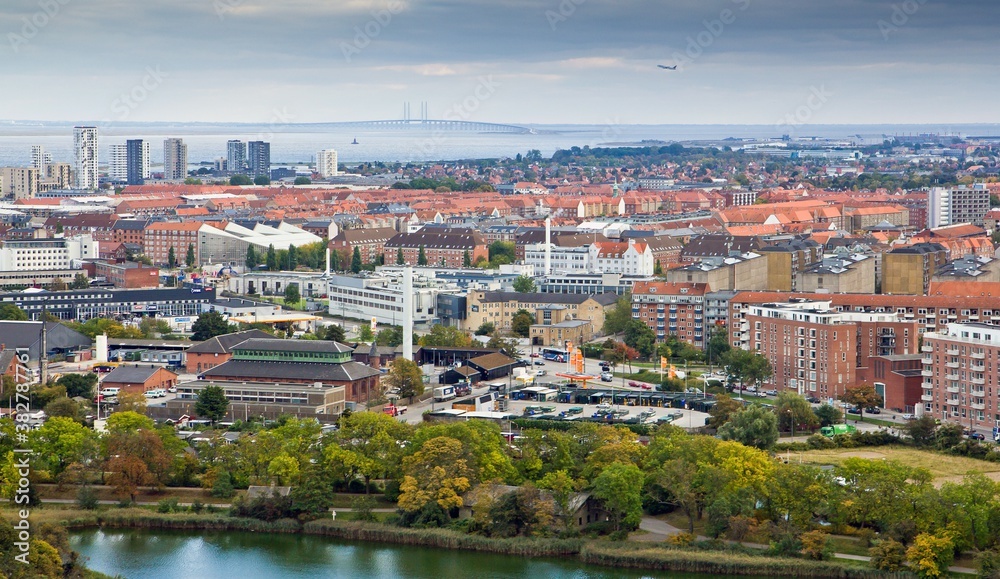 Fototapeta premium COPENHAGEN, DENMARK - OCTOBER 12, 2015. Aerial view on many red houses, streets, cars and bridge in the background in autumn in Copenhagen, Denmark.