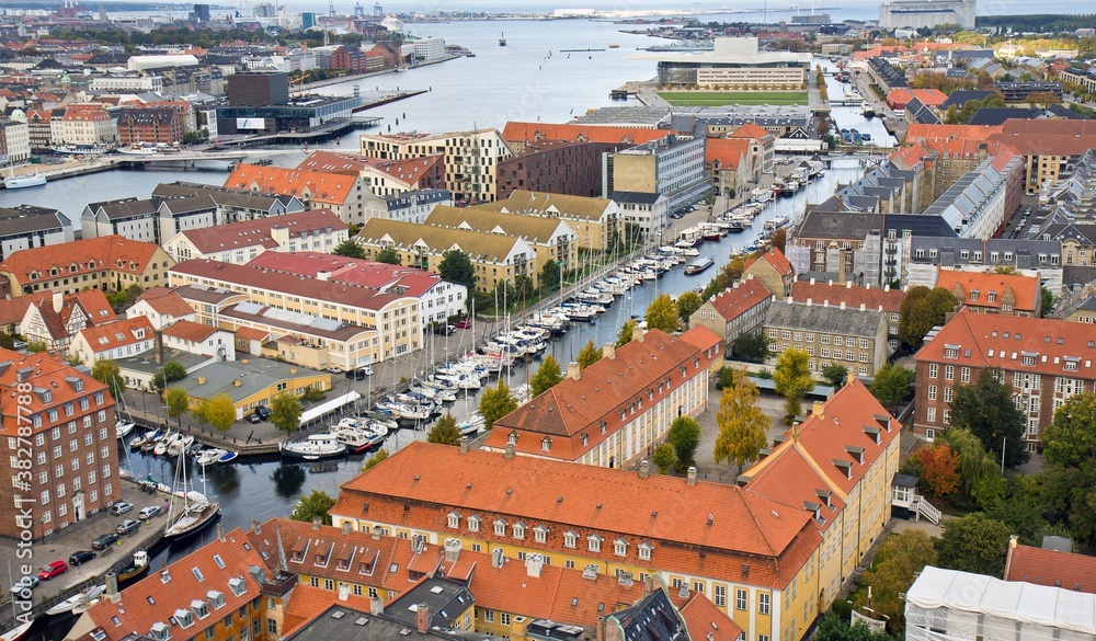 COPENHAGEN, DENMARK - OCTOBER 12, 2015. Aerial view on many red houses, white moored motor boats in line, narrow channel in autumn in Copenhagen, Denmark.