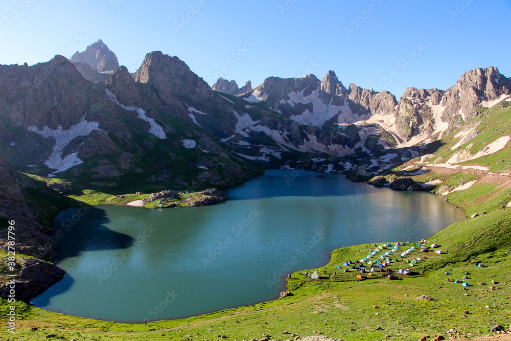 a glacial lake in mountains, winter season, cold weather and blue sky, snowy mountains
