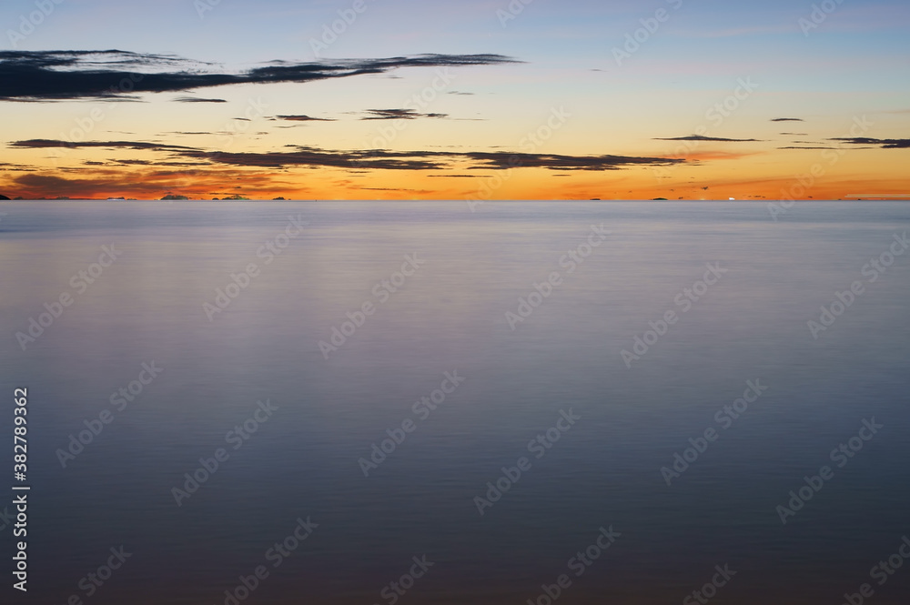 sunset sunrise on calm sea or gentle ocean wave with golden sky or red and orange sunlight on marine twilight with blue water and cloud for morning landscape scene and nature night scenic or summer