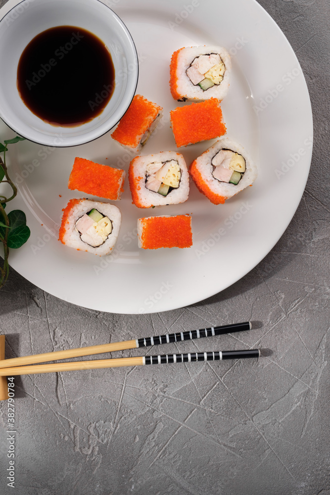 Untraditional Japanese sushi roll masaga caviar with with ham, cucumber and Japanese omelet,