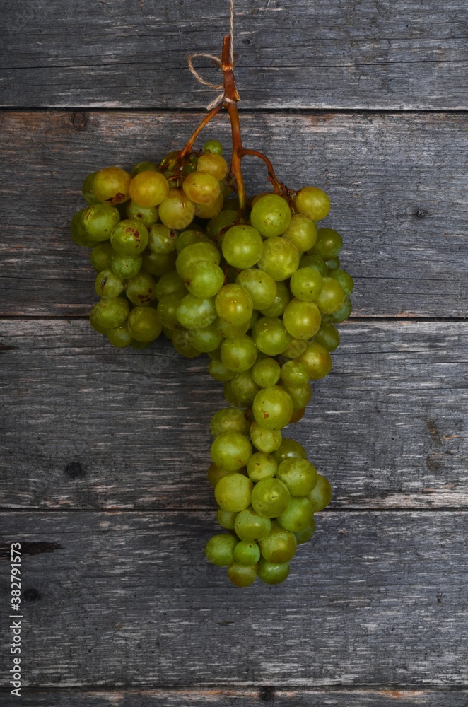 A large bunch of yellow green grapes on a wooden board background. ripe juicy green grapes, copy space A large bunch of yellow green grapes on a wooden board background. ripe juicy green grapes, copy space