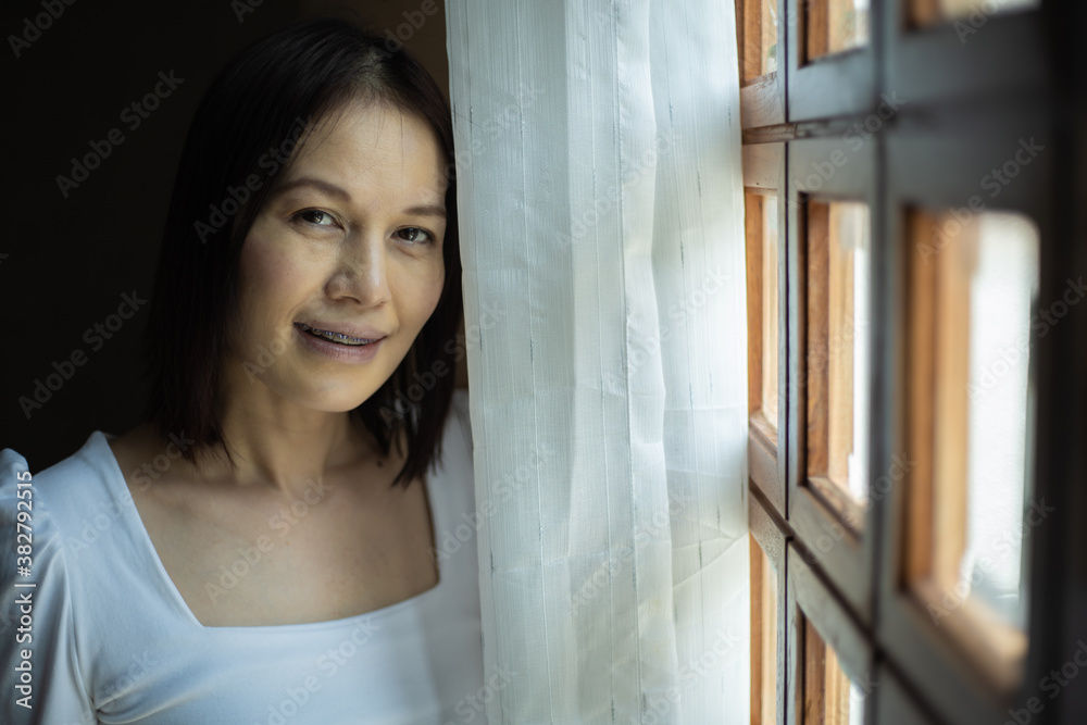 Portrait of middle-aged woman smiling friendly and looking in camera in living room. Portrait of middle-aged woman smiling friendly and looking in camera in living room.