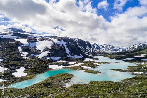 Scenic Gamle Styrnefjellsvegen with turquoise lake and snowcapped Mountains, Grotli, Norway © CA Irene Lorenz